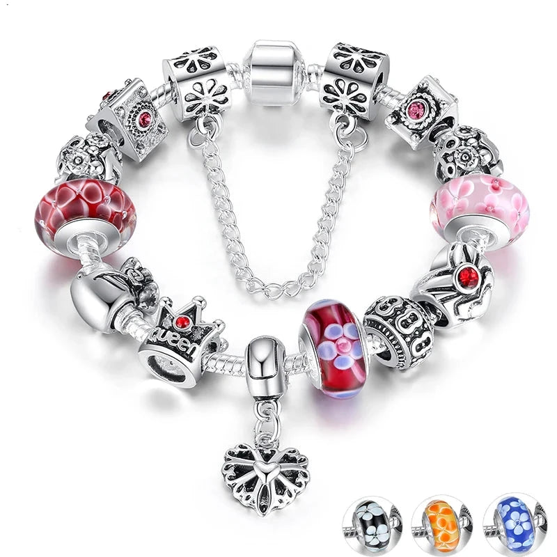A silver-colored charm bracelet featuring a variety of glass and metal charms, including floral patterns and crown motifs.