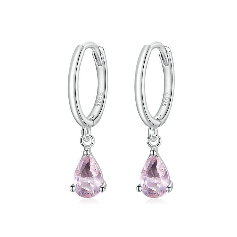 A pair of silver hoop earrings with green zircon stones attached to the hoops.