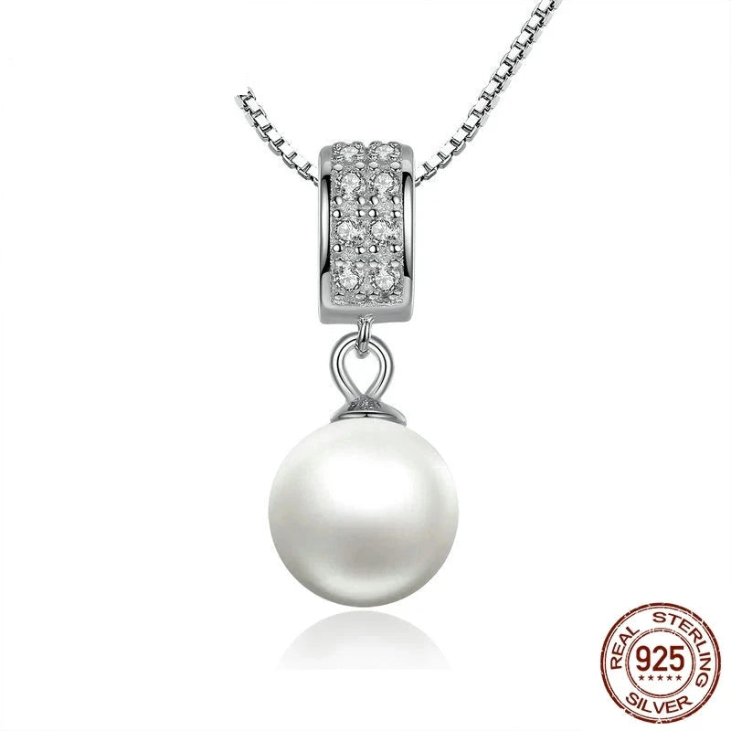 A sterling silver necklace featuring a link chain and a central simulated pearl pendant, adorned with a zircon.