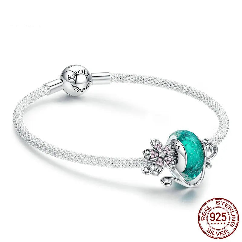 A sterling silver bracelet with a daisy flower design, featuring green glass beads and a chain structure.