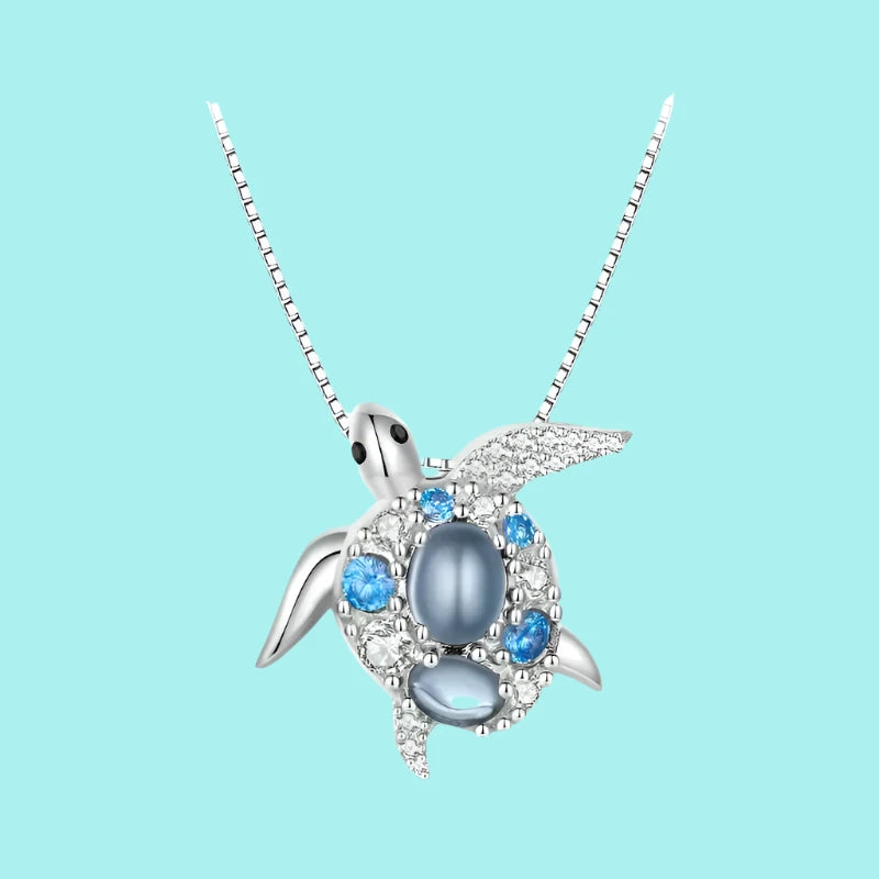 A 925 sterling silver necklace featuring a blue spinel sea turtle pendant with a silver and blue chain.