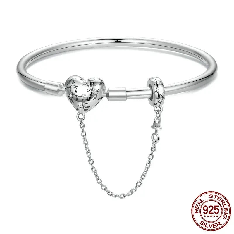 A sterling silver charm bracelet with a heart-shaped zircon stone in the center, attached to a chain of silver beads.