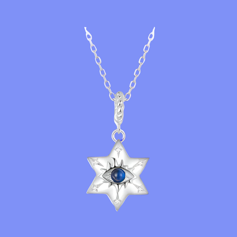 A sterling silver necklace featuring a star-shaped pendant with a blue and clear spinel stone in the center, marked with '925 Sterling Silver' and a certification symbol.
