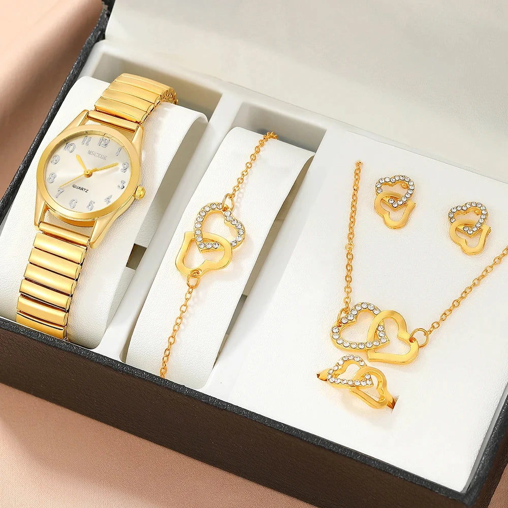 A women's quartz watch set with a gold stainless steel band and a round gold case, presented in a black box with a glass dial window. The set includes a matching necklace with a heart-shaped pendant.