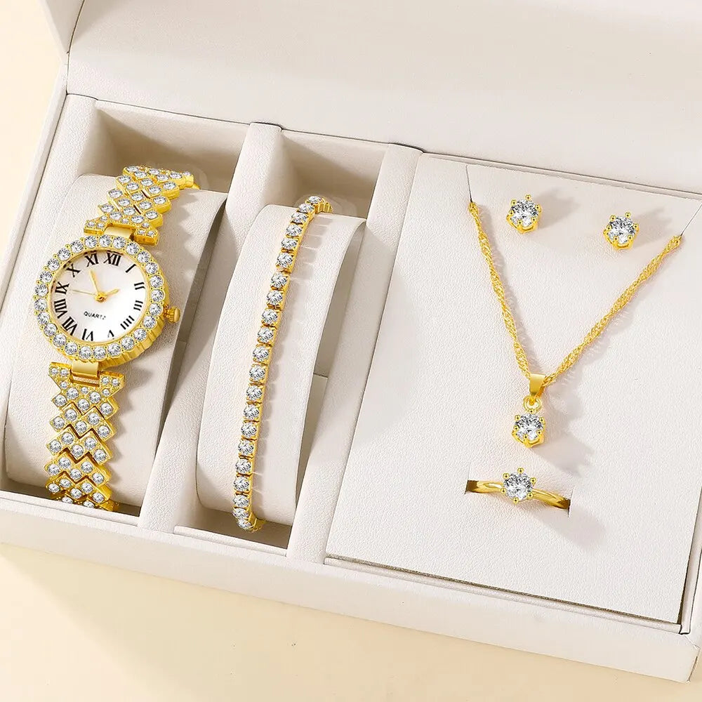 A watch with a gold band and a round dial with a gold case, accompanied by a matching necklace and earrings, presented in a white box.