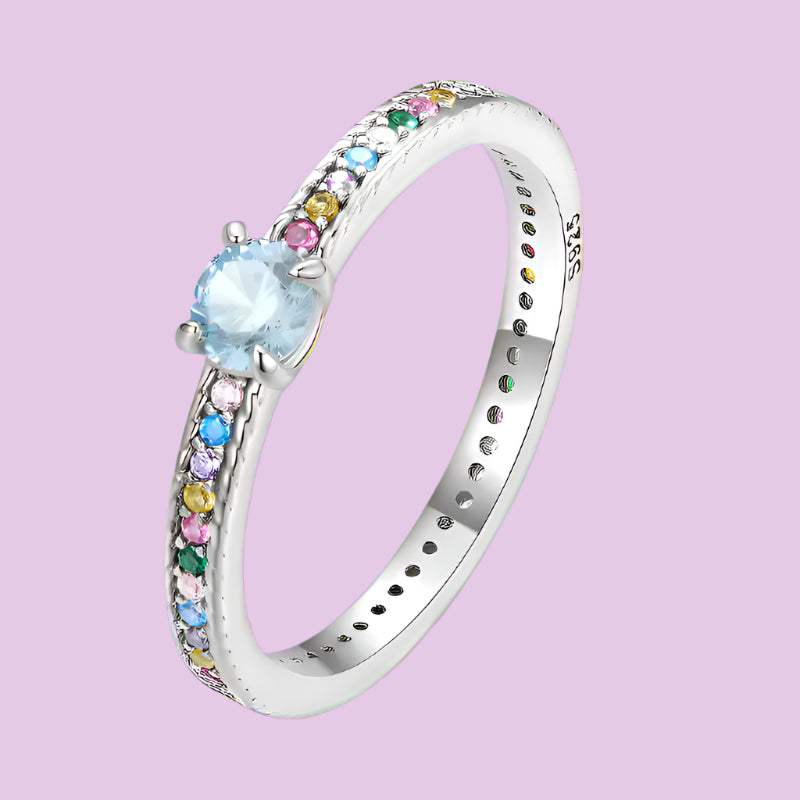 A 925 sterling silver multicolor zircon ring with a round main stone and colorful zircon side stones set in a fine silver band.