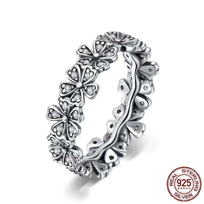 A 925 sterling silver ring with a vintage design, featuring a daisy flower pattern with heart motifs and small zircon stones set within the flowers.