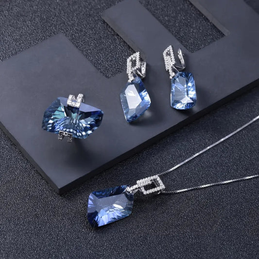 Jewelry set with blue gemstones on a dark textured surface
