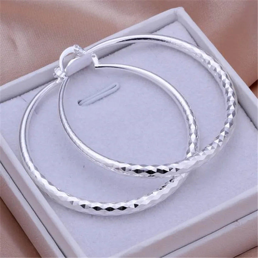 A pair of 925 sterling silver hoop earrings displayed in a white box.