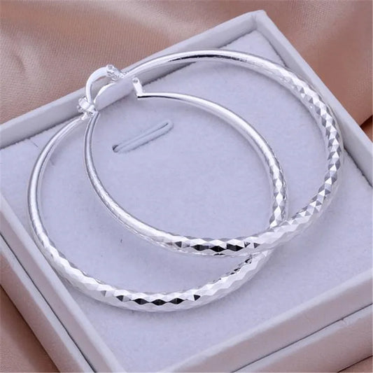 A pair of 925 sterling silver hoop earrings displayed in a white box.