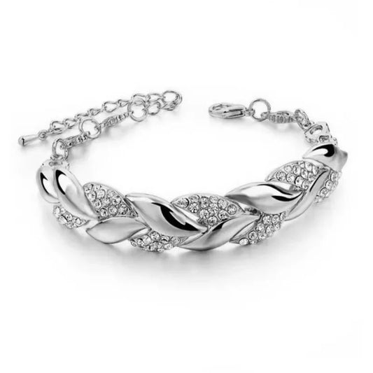 A silver-colored braided leaf bracelet with a charm, adorned with small crystals.