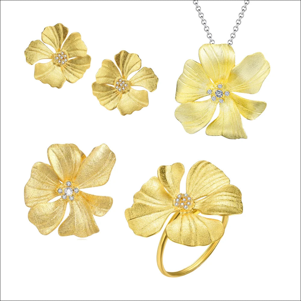 A gold floral jewelry set featuring a flower pendant necklace on a chain, two matching flower stud earrings, and a flower ring, all with textured petals and small clear crystal centers, displayed on a white background.