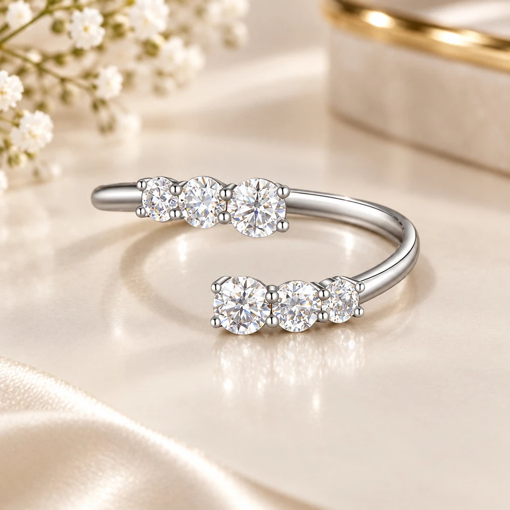 Silver bow-shaped ring with clear stones on a dark background, 