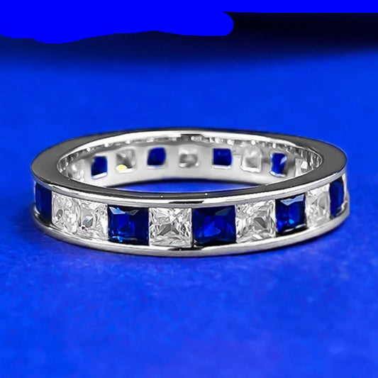 Silver ring with blue and clear gemstones on a blue background